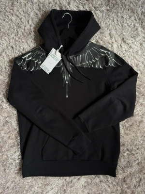 Marcelo Burlon hoodie - Marcelo Burlon Hoodie i storlek S. Svart/grå färg. Mycket fint skick (9/10) utan hål, fläckar eller andra defekter. Använd men väl omhändertagen