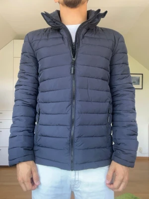 Mörkblå dunjacka från Superdry - Mörkblå dunjacka från Superdry. Strl S. Inga defekter. Modellen är 178 cm och väger 77 kg. Hör gärna av dig vid frågor!