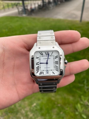 Cartier Santos medium - Säljer nu en fin Carti klocka som är en 1:1, kommer med lådan, lite billigare då denna är använd 1 gång och plastet på klockan är borta