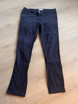 Mörkblå chinos från Strömberg - Snygga mörkblå chinos från Strömberg med klassisk rak passform och diskreta fickor fram. Tillverkade i ett mjukt och bekvämt bomullsmaterial med knapp och dragkedja i midjan. Perfekta för en stilren och avslappnad look.