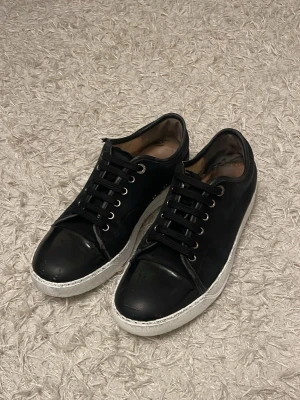 Lanvin skor - Snygga svarta sneakers med lågt skaft och vit sula och en stilren design med glansig. Passar perfekt till streetwear och vardagsstil. I bra skick med nypris av 5000kr om du undrar över nåt kan du bara fråga. Pris kan diskuteras 🤩👌