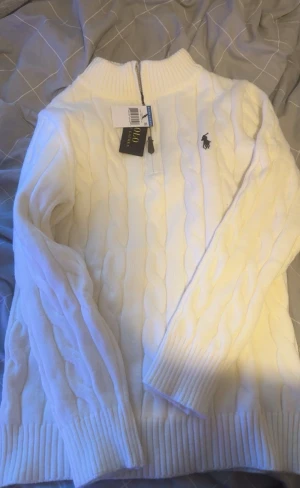 Vit slim fit  kabelstickad tröja Ralph Lauren - Riktig fresch snygg Kabelstickad vit tröja från Ralph Lauren kan passa som s med den är mer slim fit 
