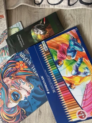 Färgläggningsbok och färgpennor set - Säljer två kreativa färgläggningsbäcker fylld med detaljerade motiv och två askar färgpennor i olika färger. 