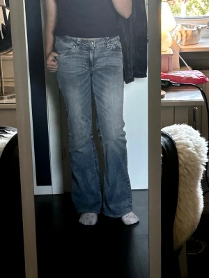 Nelly Royal Bootcut  - Säljer ett par ljusblå royal bootcut jeans från Nelly. Ett par snygga ljusblåa bootcut jeans med inget till ytters lite tecken på slitage i bra skick, inga fläckar eller andra skavanker. En sten på backfickan har lossnat men inget man lägger märke till alls. Inerbens längd 76cm midja 35cm dom är alltså uppsydda 