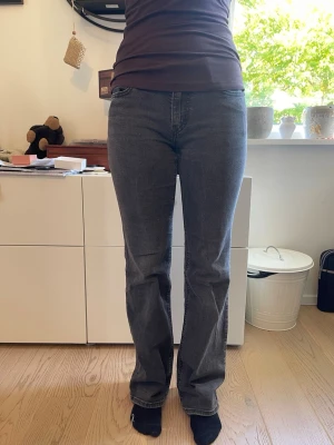 Grå raka men ändå bootcut jeans från Levi's - Säljer ett par grå jeans från Levi's med rak men ändå bootcut passform och klassiska fyra fickor. Jeansen har en diskret tvättad look och Levi's röda logga på bakfickan. Perfekta till en avslappnad stil och passar till det mesta i garderoben. Säljer då jag knappt har använt de