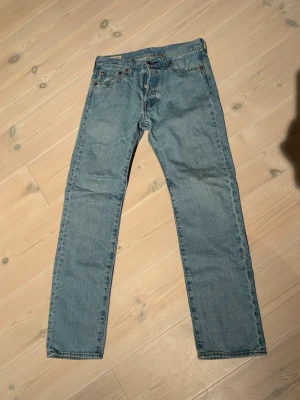 Ljusblå raka Levis jeans  - Klassiska ljusblå jeans med rak passform och fem fickor. Jeansen har normal midja och är tillverkade i denim med en tidlös tvätt. Perfekta för en avslappnad och stilren look.