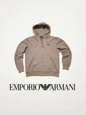Beige hoodie från Emporio Armani - Stilren beige hoodie från Emporio Armani med dragkedja framtill, justerbar huva och två fickor. Tillverkad i mjukt material och har diskret logga på bröstet. Tröjan är sparsamt använd. Kom med förslag. OBS: Tröjan är markerad I storlek XL men är mer M/L.