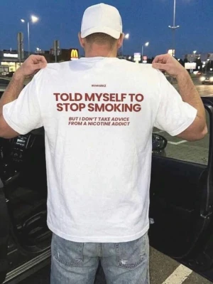 Vit t-shirt med tryck på ryggen - Vit t-shirt med stort tryck i rött på ryggen där det står 'TOLD MYSELF TO STOP SMOKING'. Klassisk passform och rund hals. Perfekt för dig som gillar statement-plagg och vill sticka ut med ett budskap.