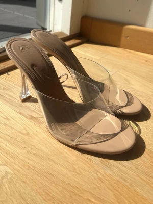 Beige transparenta pumps från Zara -  Zara klackar i storlek 37 med transparent rem och klack. Smått skrapat på sidorna av båda fötterna men syns inte mkt när man har på sig. 
