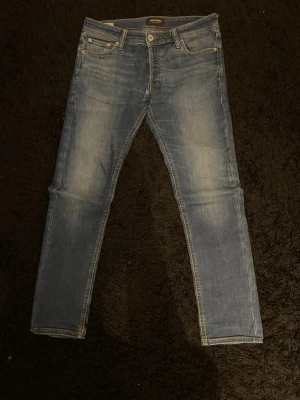 Jack & Jones jeans, W30 - Säljer ett par fina mörkblåa slim jeans från Jack and Jones i modellen Glenn. Jeansen är i bra skick med en fin tvätt. Lappen där bak är lite trasig men inget som påverkar enligt mig.                                                  Storlek: W30 L30.                                                                 Skickar inom 24h efter köp✅hör av er vid frågor!