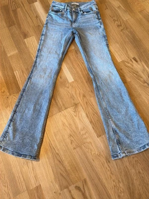 Ljusblå utsvängda jeans, storlek 34 - Säljer ett par ljusblå jeans bootcut jeans. jättefina och sköna att ha på sig!
