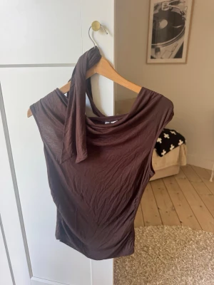Brun oneshoulder topp med knyt - Hm - Garderob utrensning! Säljer billigt för att jag gärna vill bli av med det snabbt 💕 aldrig använt toppen - prislappen kvar! 