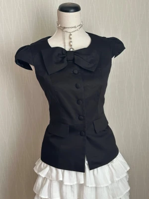 Svart blus med rosett från Sout - M/S