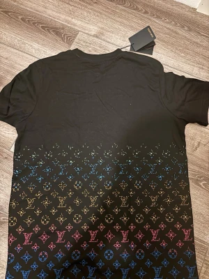 Snygg färgglad t-shirt - En snygg t-shirt som är färgglad med svart bakrund, helt ny och väldigt fin. den är i storlek M och är unisex så det passar alla. Vid frågor skicka pm😁