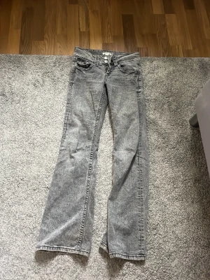 Grå tvättade jeans från Gina Tricot - Säljer ett par lågmidjade grå tvättade jeans från Gina Tricot i storlek 158. 