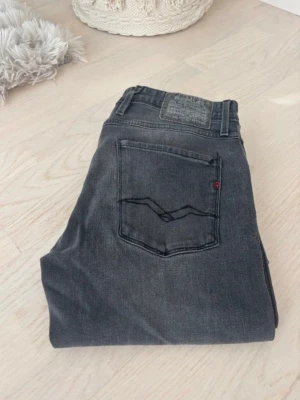 Replay ”ambass” jeans - Snygga mörkgrå slim fit jeans med klassisk femficksdesign och diskreta slitningar. Jeansen har raka ben. Perfekta till vardagslooken och passar till det mesta. Tillverkade i mjukt denimtyg för skön känsla.