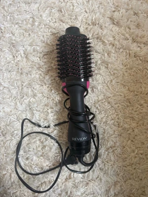 Revlon svart och rosa varmluftsborste - En svart och rosa varmluftsborste från Revlon med rund borste och täta borststrån. Perfekt för att styla och torka håret samtidigt. Ergonomiskt handtag och lång sladd för enkel användning. Har använt den typ två gånger bara!💗
