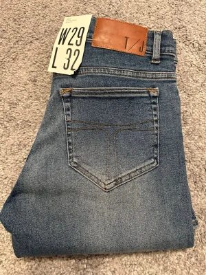 Tiger of sweden jeans 👖  - Snygga blå slim fit jeans från Tiger of sweden med klassisk femficksdesign och lätt slitna detaljer på låren. Jeansen har normal midja, dragkedjegylf och är tillverkade i stretchigt denim för en bekväm passform. Den är helt nya och tveka inte på att höra av dig vid minsta lilla fråga!