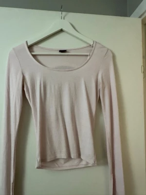 Ljusrosa långärmad topp - En enkel och stilren ljusrosa topp med lång ärm och rund halsringning. Modellen är figurnära och passar perfekt till både jeans och kjol. Materialet känns mjukt och stretchigt, vilket gör den bekväm att bära hela dagen.