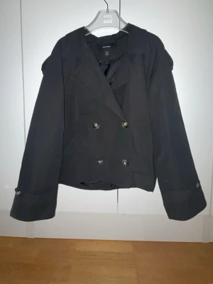 Svart skepparkavaj med dubbelknäppning - Storlek xl men sitter som en S!! Stilren svart skepparkavaj med klassisk dubbelknäppning och bred krage. Jackan har dekorativa knappar på ärmsluten och en rak, något kortare passform. Perfekt för dig som vill ha en tidlös och trendig look till hösten eller vintern.