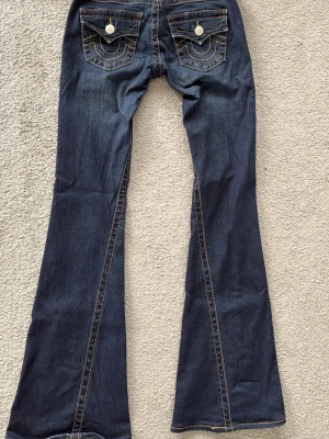 True Religion mörkblå joey - Mörkblå bootcut jeans från True Religion i modellen joey. De är i bra skick, väldigt fina