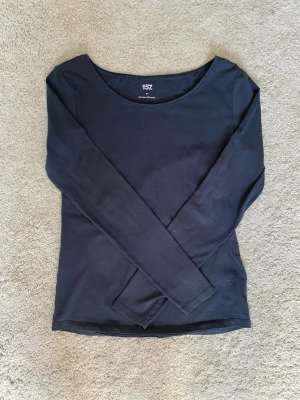 Mörkblå långärmad topp - En enkel och stilren mörkblå långärmad topp med rund halsringning. Tillverkad i mjukt material som sitter skönt mot kroppen. Skön och luftig.