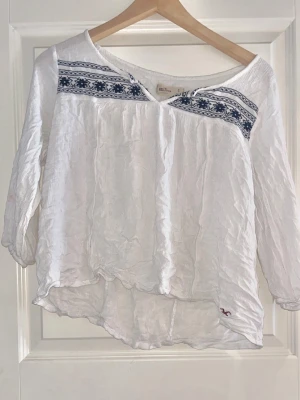 Vit blus med marinblått mönster från Hollister - Vit blus med marinblått mönster från Hollister. Finfint skick! Den behöver strykas dock, men jag har inget strykjärn, hoppas det är lugnt! 🚨Tar bara emot betalningar via Swish!!! Om du vill ha fler bilder eller har frågor är det bara att skriva till mig!!!🚨