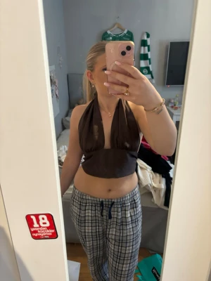 Mörkbrun satintopp - En super snygg mörkbrun satintopp från Gina tricot som är perfekt för en utekväll eller något finare tillfälle. Den är nästan som ny och har inga skador. Man knyter den själv i ryggen och kan därför anpassa den mycket utifrån sin egna kropp men den är i storlek 38(M).💞