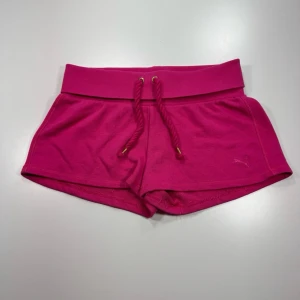 Puma Rosa shorts med snörning - Snygga rosa shorts med bred resår i midjan och snörning framtill. Tillverkade i mjukt material som passar perfekt för sommarens alla äventyr. Sportig och bekväm passform.0371