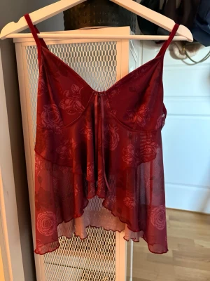3 st oanvända bommiga toppar med rosett - 3 toppar med blommigt mönster och smala axelband. Färger vinröd, blå och lila. Oanvända men saknar lapp. 