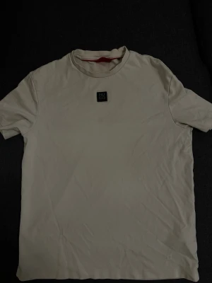 Vit t-shirt från Hugo Boss - Snygg vit t-shirt från Hugo Boss med klassisk rund hals och diskret logga på bröstet. Enkel och stilren design som passar till det mesta. Tillverkad i mjuk bomull för skön känsla hela dagen.