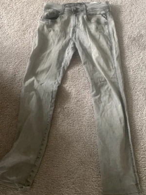 Ljusgrå slim fit jeans - Säljer ett par ljusgrå replay slim fit jeans. Jeansen har diskreta sömmar och en enkel look som passar till det mesta. Materialet är denim i bomull med lite stretch för extra komfort. Dem är nästan helt oanvända och inga skavanker!