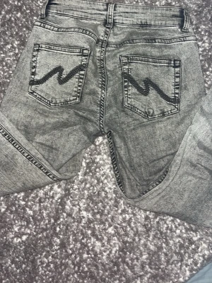 Grå tvättade jeans med sömmar-detalj köpta från Nelly! - Säljer ett par grå tvättade jeans med sömmar på bakfickorna. Jeansen har klassisk femficksdesign och raka ben. Köpta ifrån Nelly för inte så länge sedan använt 3 gånger max. Älskar dom men dom är lite för stora då för just mig men gick och ha på sig dom ändå!