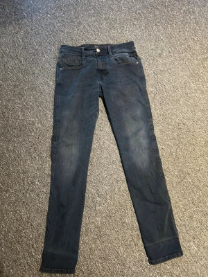 Mörkblå slim jeans från Replay - Snygga mörkblå skinny jeans från Replay med klassisk slitning och  femficksdesign och silverfärgade detaljer. Jeansen har en smal passform och är tillverkade i stretchigt denimtyg för extra komfort. Perfekta för en trendig och avslappnad look.