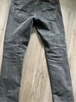Mörkgrå nudie jeans  - Snygga nudie jeans i grim tim gråa i storlek 30/30 lite skitna vid gylfen annars är den i fint skick billigare vid snabb affär 