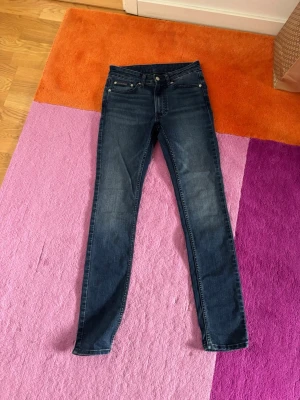 Mörkblå skinny jeans med stretch - Säljer ett par mörkblå skinny jeans med klassisk femficksmodell och smal passform. Jeansen har normal midja och är tillverkade i stretchigt denimtyg för extra komfort. Perfekta till en avslappnad och trendig look.