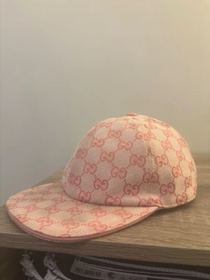 Rosa keps - Säljer en snygg rosa keps med det klassiska i en ljus och mörkare rosa ton. Kepsen har böjd skärm och justerbart band bak i rosa läder. Perfekt accessoar för dig som vill sticka ut med en lyxig och trendig look.