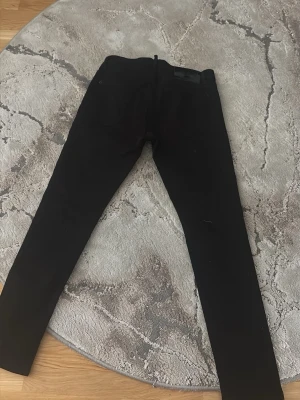 Svarta skinny jeans med hög midja - Säljer ett par svarta skinny jeans med hög midja och klassisk femficksdesign. Jeansen har knappgylf och smala ben som sitter tight hela vägen ner. Perfekta till en trendig och stilren look.