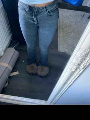 Grå tvättade jeans med fransiga benslut - Säljer ett par grå tvättade jeans med rak passform och hög midja. Jeansen har råa, fransiga benslut. Perfekta för en avslappnad och trendig look. Materialet är denim i bomull.  Dem är mellan xs-s .