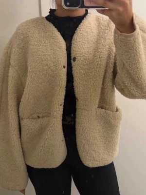 Beige oversized teddyjacka - Mysig beige teddyjacka med oversized passform och stora fickor framtill. 