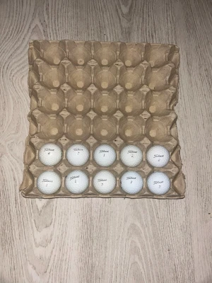 12 vita Titleist golfbollar - Säljer 12 stycken vita golfbollar från Titleist. Bollarna har klassisk rund form och är tillverkade i slitstarkt material. Perfekta för dig som vill fylla på golfväskan. Levereras i en återanvändbar pappkartong. Bollarna är tvättade och spelas med som nya (2 är ej med på bil)