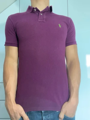 Lila piké från Ralph Lauren - Piké från Ralph lauren i 100% bomull. Strl S. Inga defekter. Modellen är 178 cm och väger 77 kg. Hör gärna av dig vid frågor!