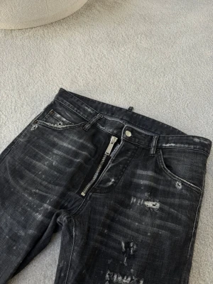 Dsquared2 jeans  - Säljer ett par svart/ gråa jeans från D2. Byxorna är i modellen Cool Guy Jean. De har en trendig passform. Jeansen är i fint skick och finns inga tecken på använing. Storleken är 48, som motsvarar en S,M.