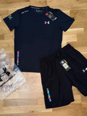 Under armour set svart - Riktigt snygg svarta under armour set. T shirt och shorts. Helt nya utan prislapp. Storleken passar perfekt för dig som har storlek L och är 180cm! 