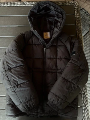 Cp company dunjacka - Säljer en snygg svart c.p company dunjacka! Jackan är i mycket bra skick och har inga defekter. Varm så perfekt till höst/vinter! Om ni har några frågor så hör av er😊