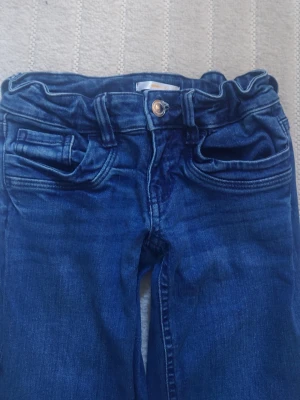 Mörkblå jeans från Gina Tricot - Snygga mörkblå jeans från Gina Tricot i storlek 152. Klassisk modell med knapp och dragkedja framtill. Använda ett få tal gånger. 
