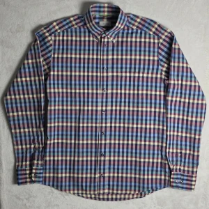 Eton Slim bomull/linne skjorta rutig blå/lila storlek L - Rutig skjorta från Eton i Slim-passform. Färgstark men stilren kombination av blått, lila, rosa och beige som fungerar både casual och mer uppklätt. Tillverkad i bomull med inslag av linne för sval och lätt känsla.  Storlek L / 41 Slim Fit  Mycket fint skick.  Mått Bröstbredd: ca 53 cm Plagglängd: ca 77 cm Axelbredd: ca 46 cm Ärmlängd: ca 68 cm  Material 95% bomull 5% linne  Button down-krage och klassiskt rutigt mönster.  Tycker du priset är för högt? Skicka ett prisförslag!