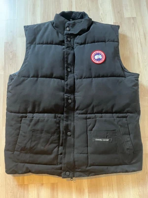 Canada goose väst  - Hej säljer nu min canda goose väst jag köpte denna sommarn i maj, säljer eftersom ganska stor för mig storlek XL men passar även vid L. Knappt använd. Vid köp drar jag även blöt handduk över den för tvättning eftersom tvätta direkt med bara vatten inte fungerar eftersom innehållet kan förstöras men regn är ju såklart inte problem med den, priser kan diskuteras vid köpet.