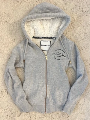 Grå zip hoodie från Superdry - Jättemysig hoodie med lurvig luva i storlek 36 