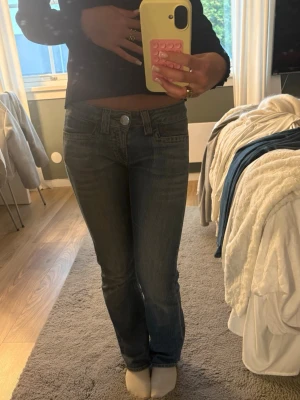 Mörkblå raka jeans med låg midja - Säljer ett par mörkblå jeans med låg midja och raka ben. Jeansen har klassiska fickor fram och bak, samt snygga sömdetaljer på bakfickorna. Perfekta för en avslappnad och trendig look. Materialet är denim med lätt stretch för extra komfort. W25 L30